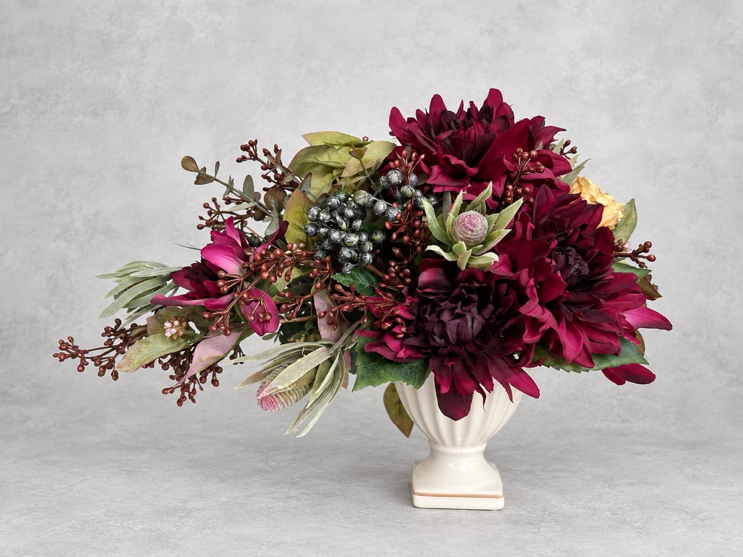 ボルドーの花と実ものが横に広がる季節のアレンジメント