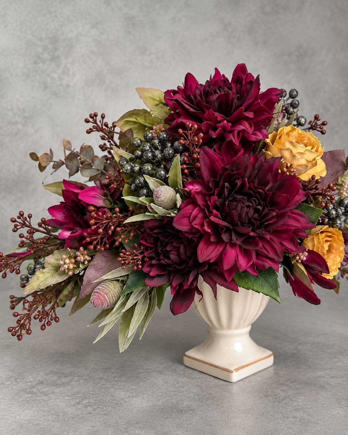 ボルドーの花と実ものを重ねた季節のアレンジメントのクローズアップ